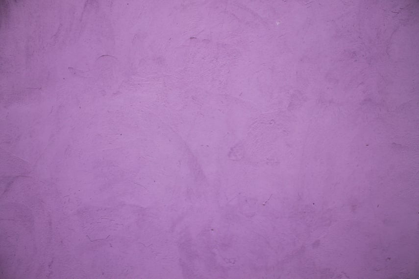 Shabby wall of lilac color. Grunge texture.